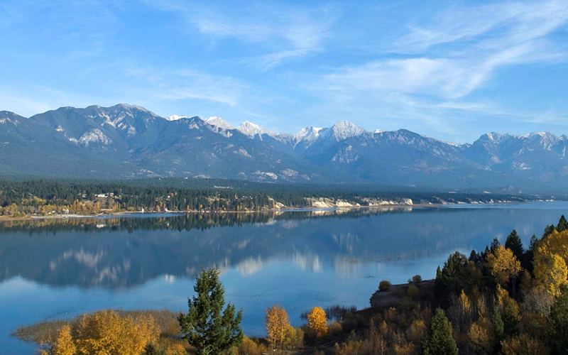 Photo of beautiful autumn lakeview with snowcapped mountains in the background.