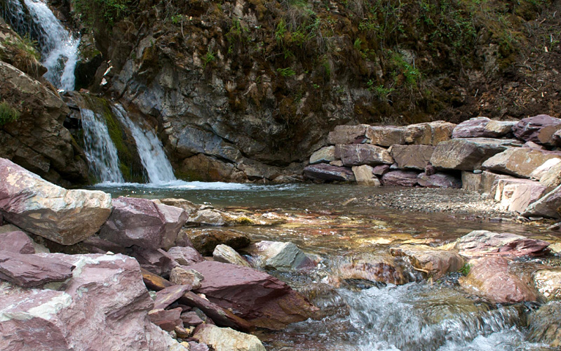 Image of small water fall on rocky river banks.